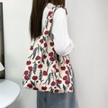 Detail showing red poppy floral print on beige canvas tote bag worn by a model - Poppy