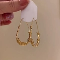 Detail von goldenen Metallohrringen mit unregelmäßiger Struktur auf einer Displaykarte - 43# Silbernadel - Gold
