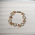 Macro detail of gold flower bracelet featuring colorful zircon petals and hollow rings - Gold Multicolor Flower