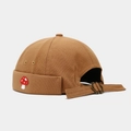 Detail of tan miki hat featuring red mushroom embroidery and metal buckle closure - Caramel color