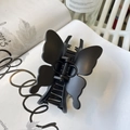 Detalle de una pinza para el pelo tipo mariposa en negro mate sobre una revista - Hebilla De Mariposa Negra Mate (aprox. 11 Cm)