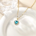 Detailed close-up of a blue heart pendant necklace with micro-paved crystal border - Lake Blue Pendant Necklace