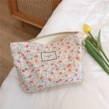 Vue détaillée d'une trousse de maquillage fleurie en coton avec fermeture éclair en métal - Fleurs Blanches Rouges