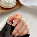 Bague croisée dorée double rangée avec zircons rectangulaires portées par mannequin - Bague En Zircon Entrecroisée