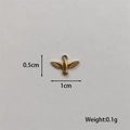 Macro shot of a tiny gold-plated bird pendant showing 1cm width and 0.1g weight details - Bird