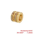Makroaufnahme der vergoldeten 6x8mm Zylinderperle mit drei Reihen aus klaren Kristallen - VZ392 Gold X-Kreuz / 6X8mm