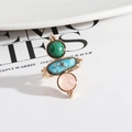 Three-stone gold ring with malachite and turquoise inlays on a ceramic jewelry tray - Pink Crystal + Malachite
