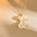 Detailed macro view of a gold-tone bear pendant with white resin and star accents - White Cross Chain