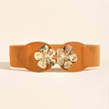 Women's brown elastic waist belt with elegant gold flower metal buckle on beige background - Tan