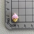 Makroaufnahme eines Mini-Eiscreme-Anhängers aus Harz mit 1,5 cm Maßstab auf einem Lineal - Rosa Punkt Eiscreme