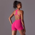 Rear view of rose pink seamless yoga romper featuring open back and racerback straps - S / Rose Pink