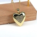 Dettaglio macro della collana con medaglione a cuore dorato e zirconi su catena a sfere - Medaglione a Cuore