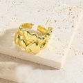Detail view of the golden heart-shaped ring with linked design on a stone base - Linked Hearts Style
