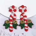 Detailed close-up of handmade beaded Christmas candy cane earrings with red and white pearls - Style 3 (Candy Cane with Bow)