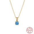 Macro shot of 925 sterling silver gold necklace with a blue round birthstone pendant - Gold-December