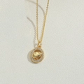 Golden Saturn necklace with crystal halo on minimalist beige textured background - Planet