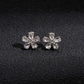 Gros plan de boucles d'oreilles fleurs argentées avec strass sur un fond sombre - Alliage / Strass / Tige en argent / Boucles d'oreilles clous fleurs (Couleur Argent)