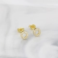 Elegant gold round stud earrings with white zircon pavé on marble background - Letter O