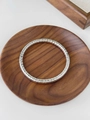 Silver plated titanium steel bangle with elegant checkered pattern on wooden background - Silver Cross Hatch