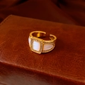 Close-up of a gold ring with a square mother of pearl stone and zircon accents - Gold-White
