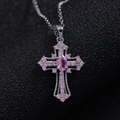Detailed macro view of punk cross pendant with pink gemstones and silver alloy base - Necklace / Silver Pink Zirconia