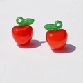 Detailed view of red acrylic apple charms with green leaves for DIY jewelry making - Solid Red Apple