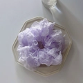 Primo piano di un elastico per capelli in chiffon viola con ruches su un piatto bianco - Viola