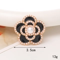 Détail de l'accessoire camélia en alliage avec perles blanches et émail noir poli - Fleur De Perle En Émail Noir