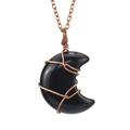 Close-up of handmade moon pendant necklace with copper wire wrap and black polished gemstone - Obsidian