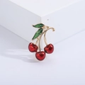 Detailed view of red enamel cherry brooch with green leaves and gold metal base - Red (MM-BR-3448-RD)