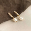 Detail of baroque pearl earrings with sparkling zircon stones on textured fabric - Style 29