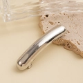 Macro detail of silver curved metal hair clip on beige stone and glass decor - Minimalist Curved Bar Hair Clip / Silver