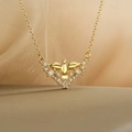 Gold plated angel wing pendant necklace with sparkling zircons on a soft silk background - Angel Wings
