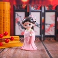 Close-up of cute Q-version female doll in pink Hanfu with floral headpiece and wood decor - Diaochan