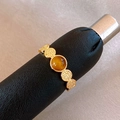 Bague vintage dorée texturée avec pierre œil de tigre ambre sur support de présentation noir - Or-Brun Rond