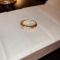 Detalle de anillo ajustable bañado en oro con tres perlas blancas en soporte de terciopelo - Dorado (13#)