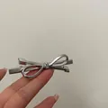 Detail shot of a minimalist silver metal bow hair clip with polished chrome finish texture - Alloy Bow Hair Clip