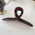 Close-up of a 15cm large tortoiseshell resin hair claw clip with a glossy twisted design - Hanger (Approx 15cm) / Glossy Red Brown