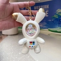 Detail of white astronaut rabbit plush keychain with golden ears and color foam balls - Space Rabbit Cream White