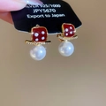 Macro shot of 18K gold plated earring with red enamel, zircons, and white pearl drop - Dice Pearl Ear Buckle (Real Gold Plating) / Red & Gold & White
