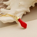Bunte Glückshand-Halskette mit Goldkette auf einem weißen Muschelhintergrund - Rot