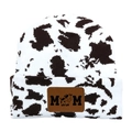 Detail of knitted cow print beanie with brown leather MOM patch and cow icon - Coffee White/Black White Cow