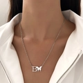 Detail of silver letter B necklace with butterfly pendant on model's neckline - Letter B Butterfly Steel Color