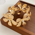 Detailed view of luxury gold flower bracelet with sparkling crystal rhinestones set in petals - Gold