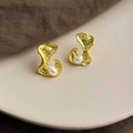 Detail of baroque pearl earrings with irregular gold lava texture on a ceramic plate - Style 19