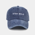 Detail of washed blue baseball cap featuring white STAY WILD embroidery and cotton texture - Adjustable / Navy Blue