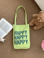 Nahaufnahme der hellgrünen Segeltuchtasche mit Happy-Aufdruck und Plüsch-Deko - Senfgrün