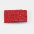 Detail of red rhinestone encrusted metal cigarette case showing fine crystal texture - Red
