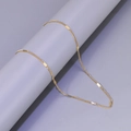 Golden Figaro chain pendant accessory in stainless steel displayed on a gray pedestal - L22-Figaro Chain / Gold