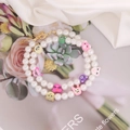 Dettaglio di due braccialetti di perle con ciondoli animali colorati e chiusura dorata - 1# Stile animale